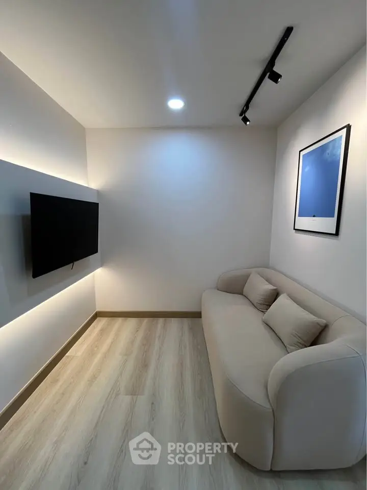 Modern minimalist living room with sleek sofa and wall-mounted TV