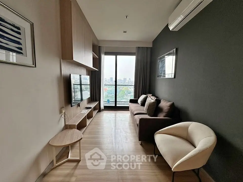Modern living room with city view, featuring sleek furniture and large window.