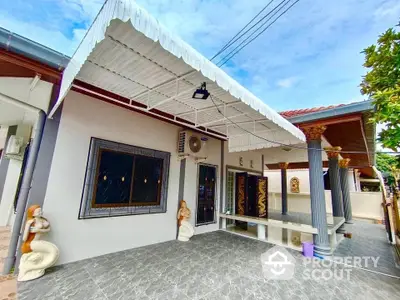 Charming single-story home with decorative sculptures and spacious tiled patio.