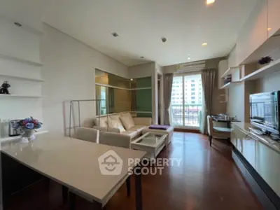 Modern living room with elegant decor and natural light, featuring a cozy seating area and stylish shelving.