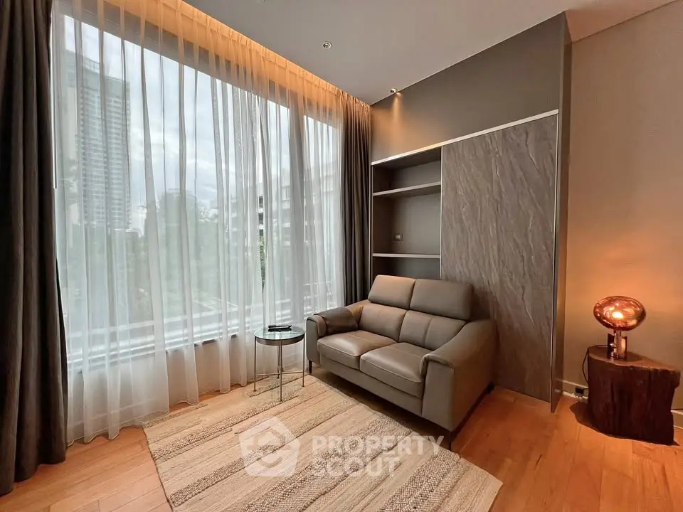Modern living room with large windows and stylish decor in a high-rise apartment.