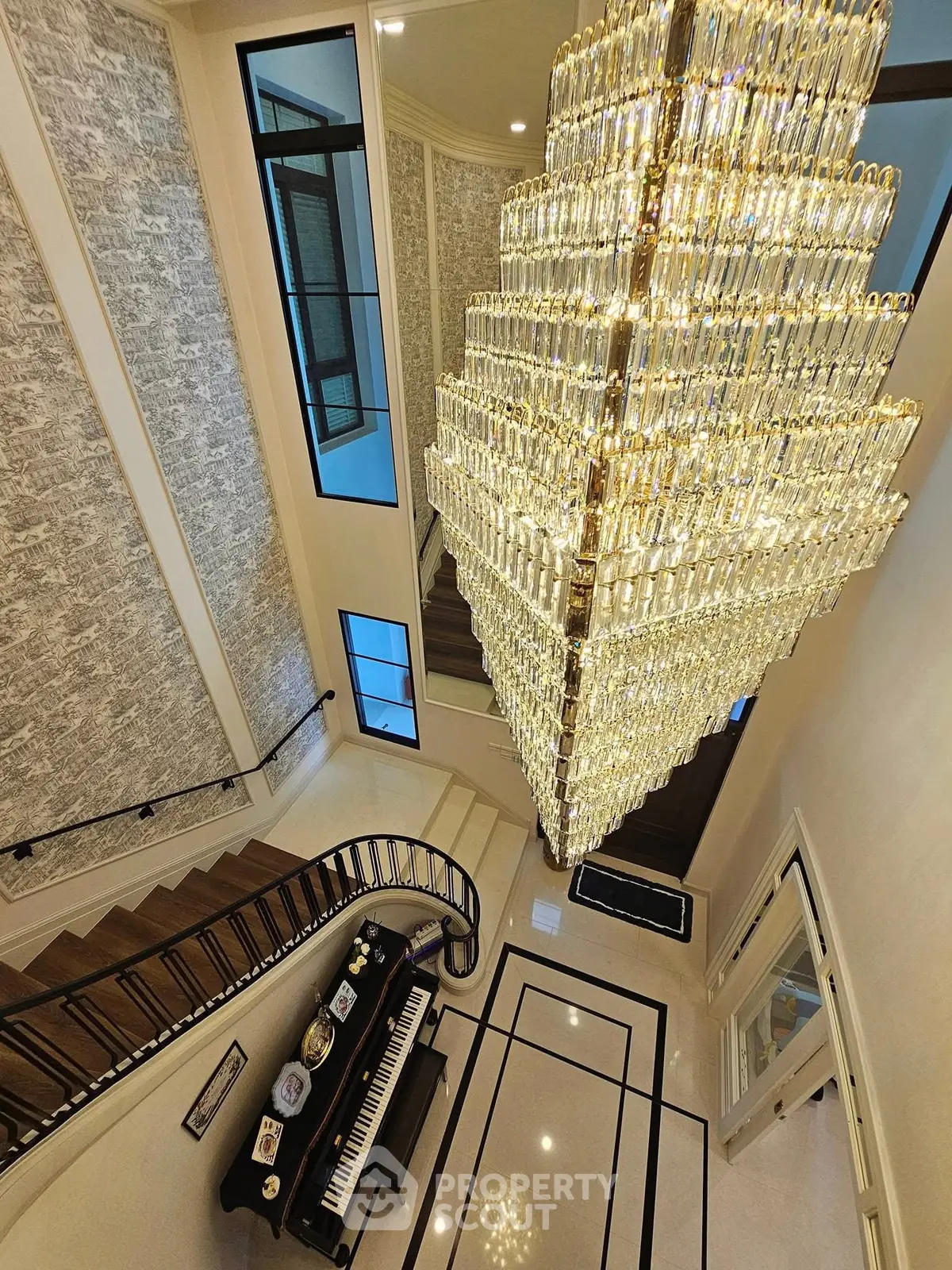 Luxurious grand entrance with stunning chandelier and elegant staircase