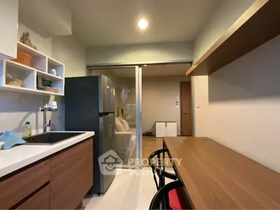 Modern kitchen with sleek design and open layout leading to cozy living area.