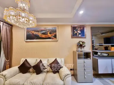 Luxurious living room with elegant chandelier and cozy sofa, perfect for relaxation.