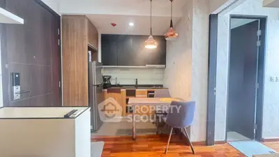 Modern kitchen with sleek design and dining area in open layout apartment.