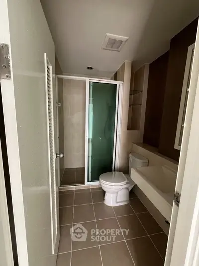Modern bathroom with glass shower and sleek fixtures in contemporary home.