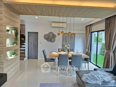 Modern dining area with elegant decor and large windows overlooking a lush garden.
