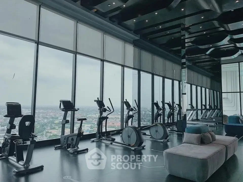 Luxurious high-rise gym with panoramic city views and modern fitness equipment.