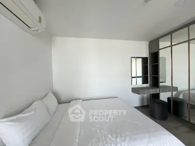 Modern minimalist bedroom with sleek mirrored wardrobe and air conditioning