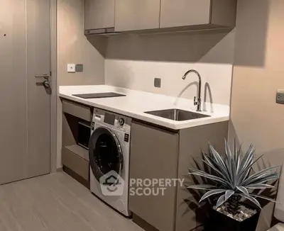 Modern compact kitchen with integrated appliances and sleek cabinetry