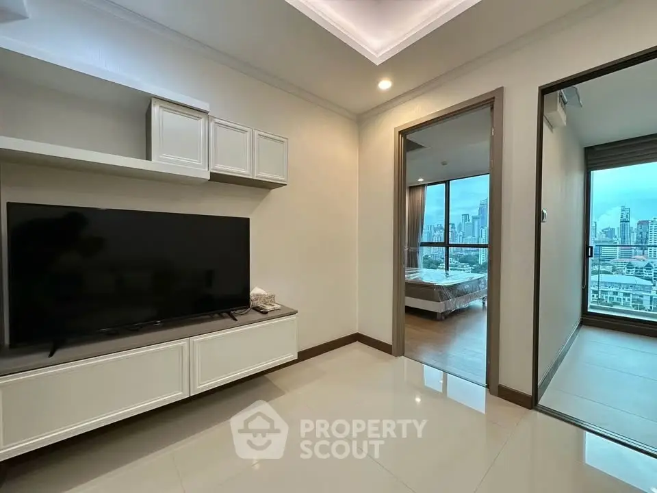 Modern apartment interior with sleek living room and bedroom view, featuring cityscape through large windows.