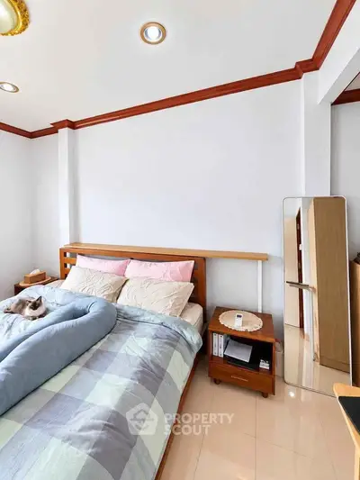 Cozy bedroom with stylish wooden bed, soft bedding, and elegant decor for a serene living experience.
