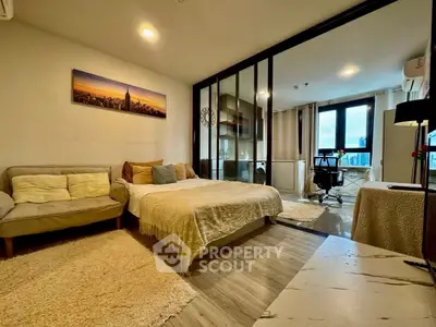 Modern studio apartment with cozy living area and glass partitioned bedroom, featuring city views.