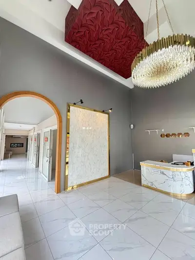 Luxurious building entrance with elegant chandelier and marble flooring
