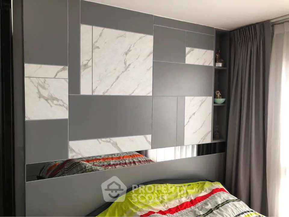 Modern bedroom with stylish geometric wall design and cozy bedding