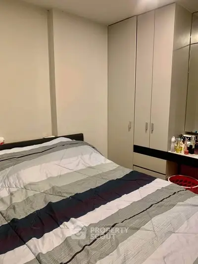 Cozy bedroom with modern wardrobe and neatly arranged bed in a stylish apartment.