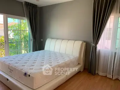 Spacious bedroom with elegant decor and large windows for natural light.