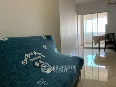 Spacious living room with stylish sofa and natural light, perfect for relaxation and entertaining.