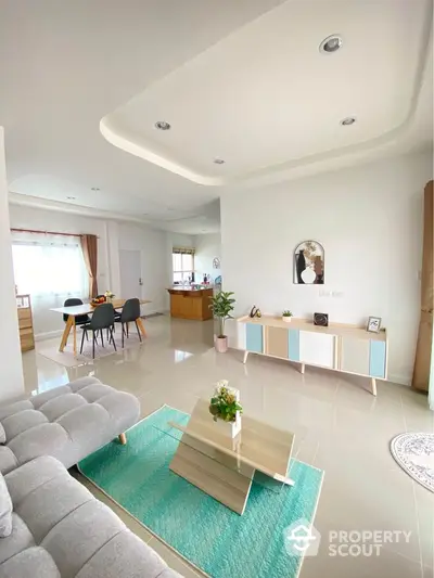 Modern living room with stylish furniture and open layout, featuring a cozy dining area and elegant decor.