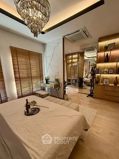 Luxurious bedroom with elegant decor, featuring a chandelier and wooden accents for a cozy ambiance.