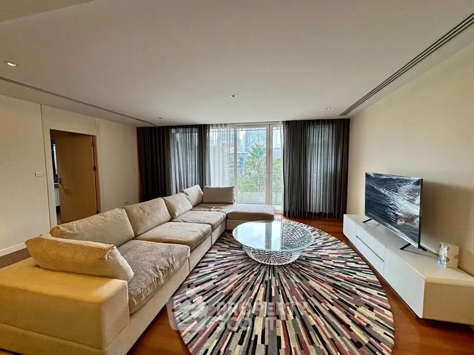 Spacious living room with modern decor and large windows offering natural light.