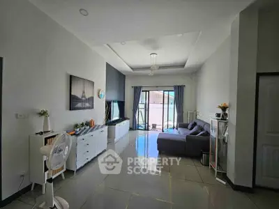 Spacious modern living room with sleek tile flooring and large windows for natural light.