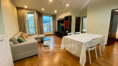 Spacious living room with modern decor and dining area in a stylish apartment.