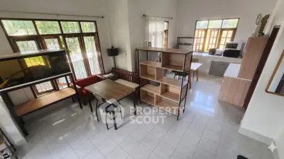 Spacious living room with large windows and modern furniture, perfect for family gatherings.