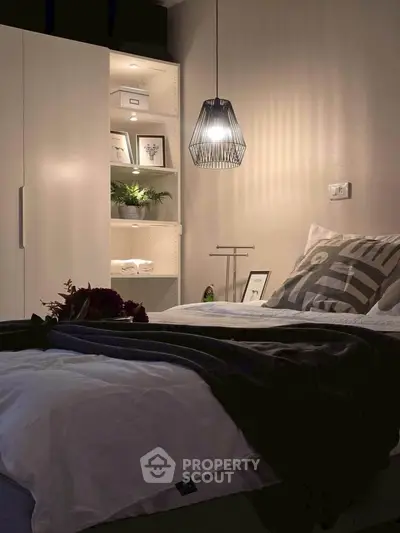 Cozy bedroom with modern lighting and built-in shelving, perfect for relaxation.