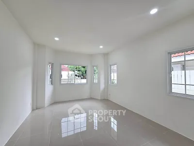 Spacious unfurnished room with large windows and glossy tiled floor, perfect for customization.