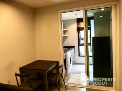 Modern apartment interior with dining area and laundry room featuring a washing machine.