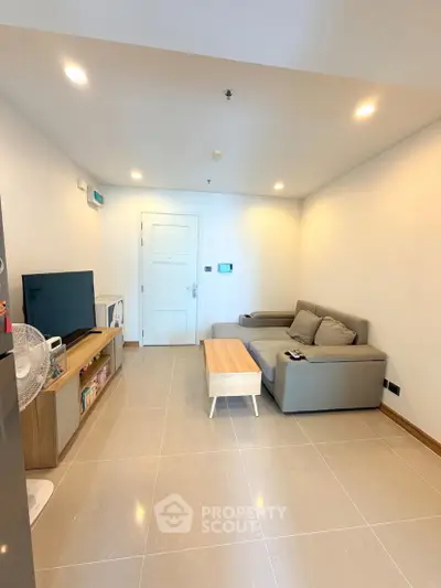 Modern living room with sleek furniture and neutral tones, perfect for relaxation and entertainment.