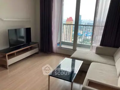 Modern living room with city view, featuring sleek furniture and large windows for natural light.