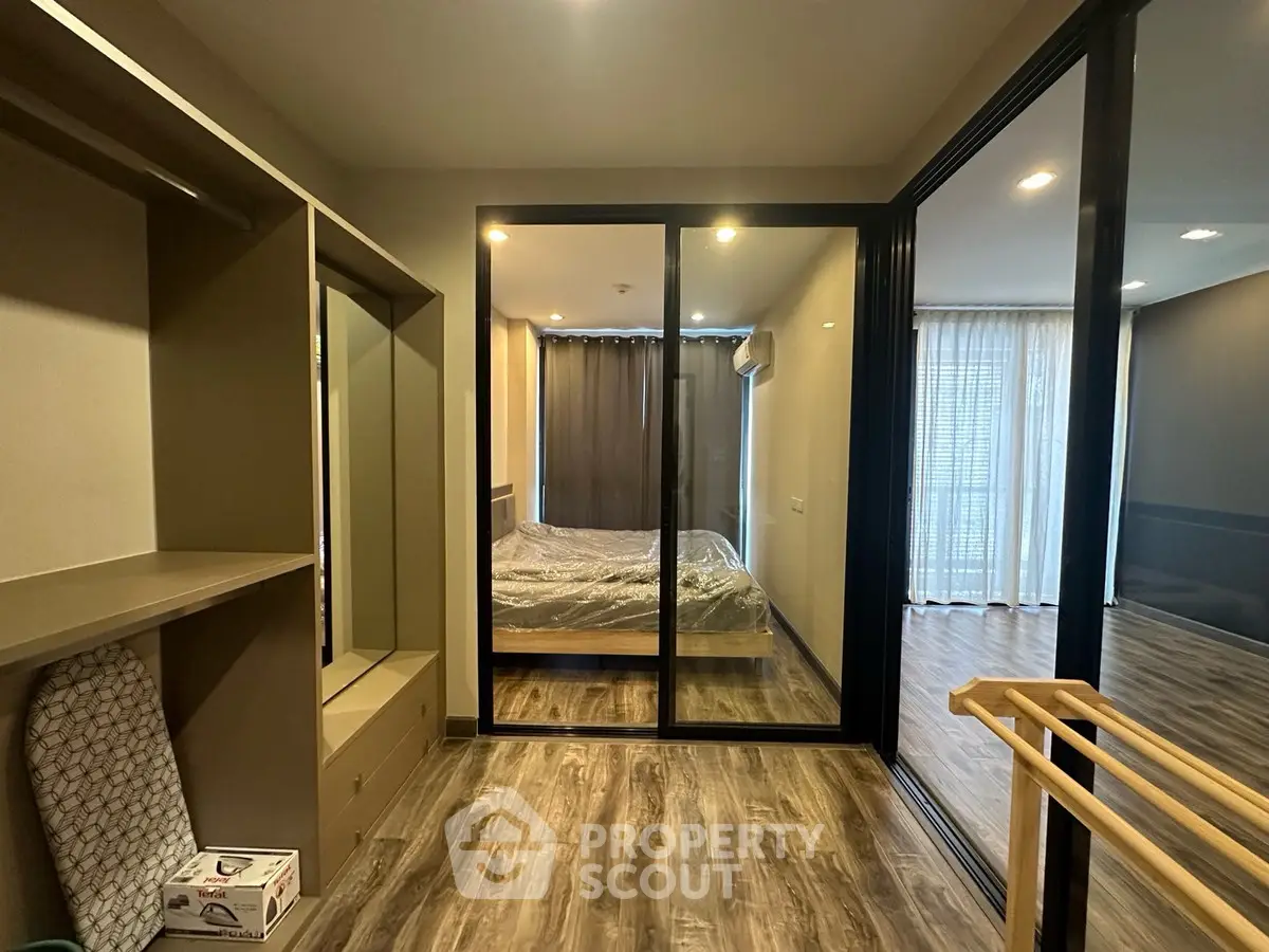 Modern bedroom with glass partition and wooden flooring in stylish apartment