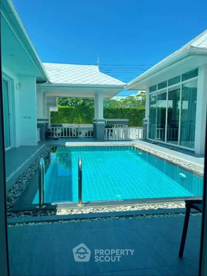 Luxurious villa with private pool and modern architecture under clear blue sky.