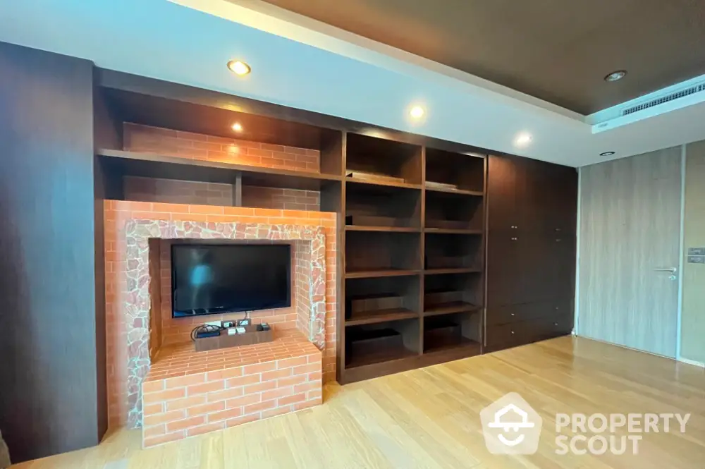 Spacious living room with built-in shelves and brick TV feature wall