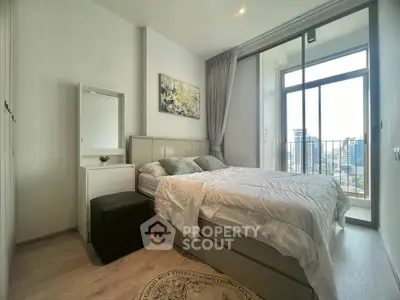Modern bedroom with balcony and city view, featuring elegant decor and natural light.