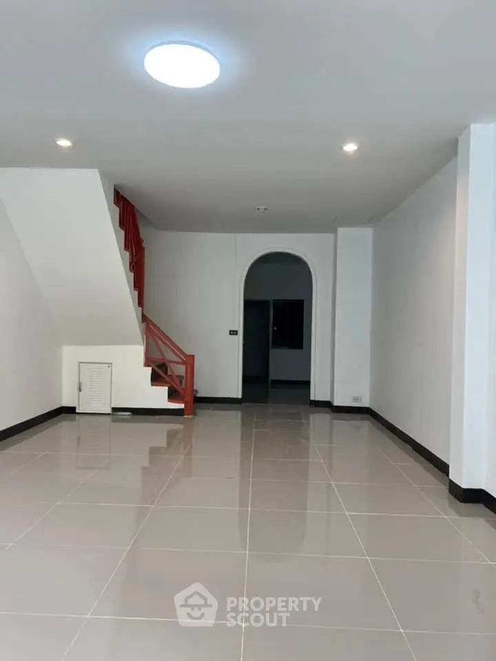 Spacious interior with modern staircase and glossy tiled floor, ideal for customization.