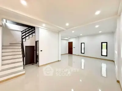 Spacious modern living room with sleek staircase and bright lighting