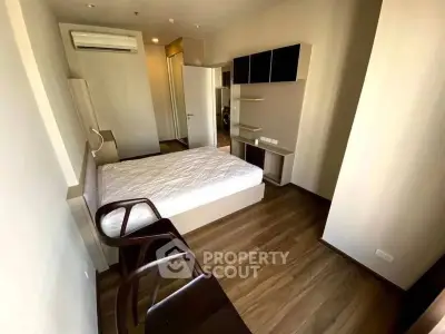 Modern bedroom with wooden flooring and built-in storage in a cozy apartment.
