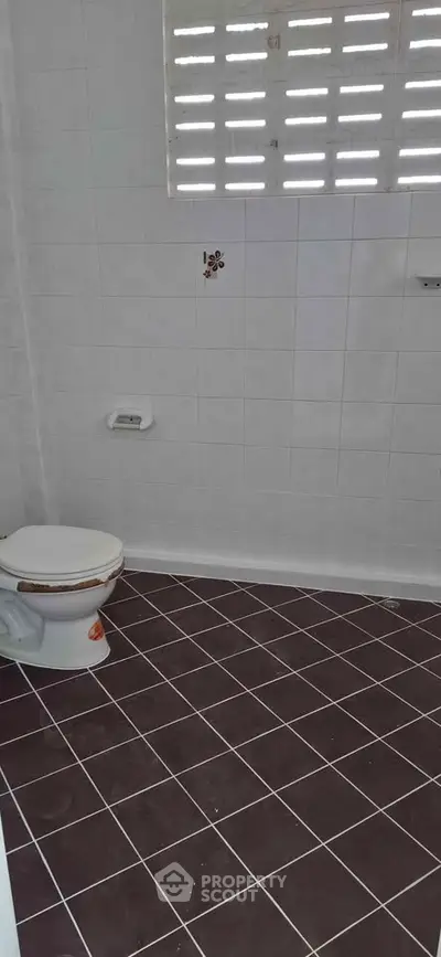 Simple bathroom with tiled floor and natural light from window