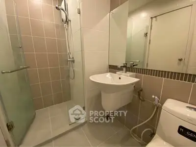 Modern bathroom with glass shower and sleek fixtures in a contemporary apartment.