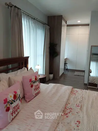 Cozy bedroom with stylish decor and ample natural light, featuring a comfortable bed and elegant furnishings.