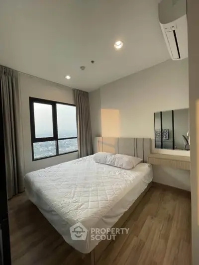 Modern bedroom with large window and city view, featuring a comfortable bed and sleek design.