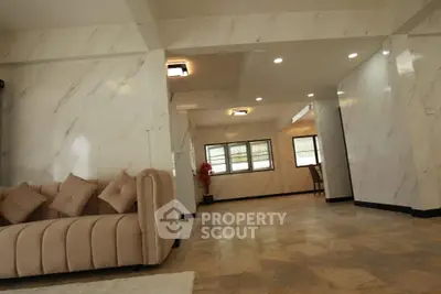 Spacious and elegant living room with marble walls and modern lighting, perfect for luxury living.