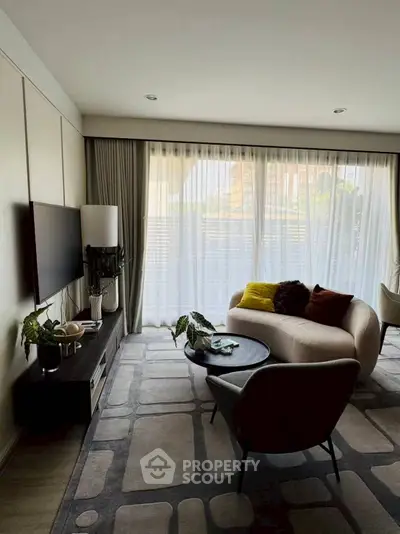 Elegant living room with modern decor and large windows offering natural light and city views.