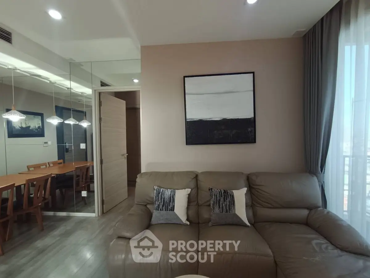 Modern living room with stylish decor and dining area in open layout apartment.