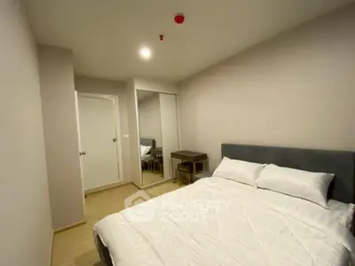 Modern bedroom with mirrored closet and cozy bed in a stylish apartment.