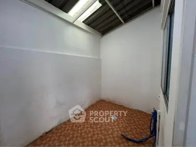 Empty utility room with tiled floor and skylight, ideal for storage or laundry setup.