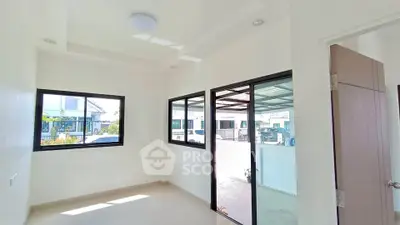 Bright and airy room with large windows and modern design, perfect for a cozy home office or study area.